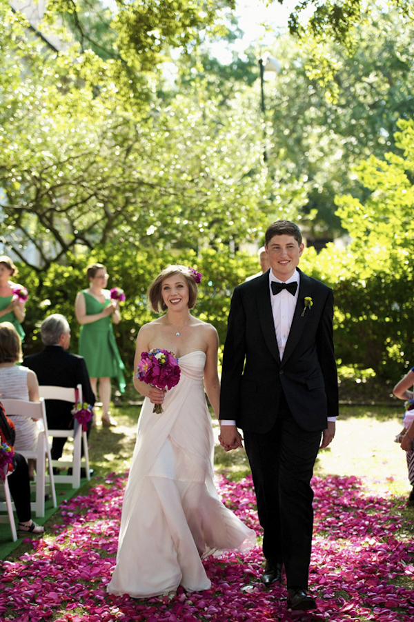 Couple exiting ceremony on an outdoor aisle of dark pink and purple petals - photo by top Atlanta-based wedding photographer Scott Hopkins Photography